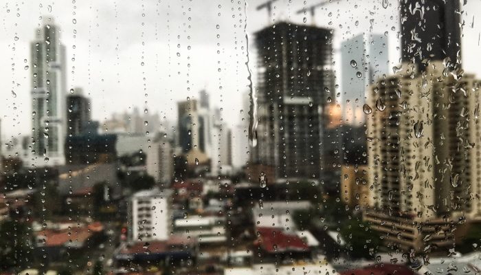 beautiful-view-raindrops-rolling-down-window-skyscrapers-surface_181624-52199