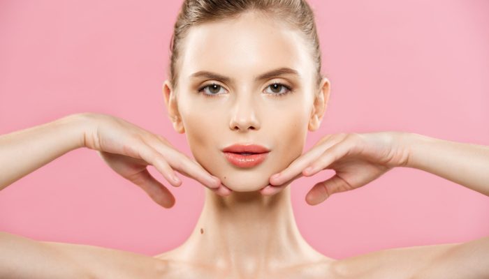 Beauty Concept - Close up Portrait of attractive caucasian girl with beauty natural skin isolated on pink background with copy space.