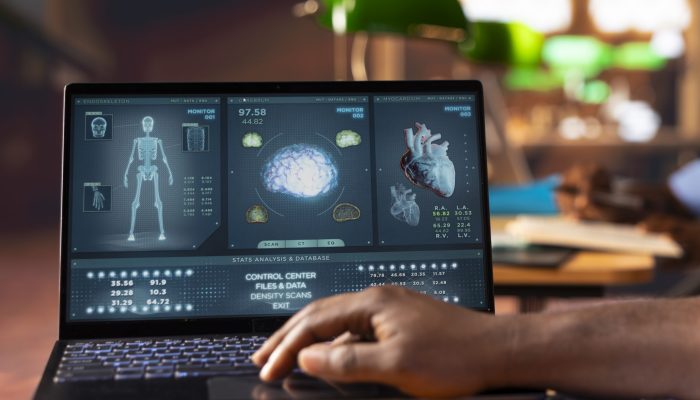 Black med school scholar studying and taking notes using online information, reviews a thesis project in the campus library. Man collecting academic data for medical research. Close up.