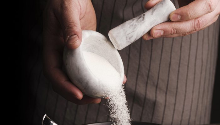 cook-adding-sugar-from-mortar-into-bowl