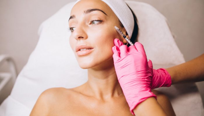 Cosmetologist making injections on a face of a woman in a beauty salon