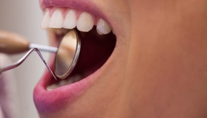 dentista-examinando-uma-paciente-do-sexo-feminino-com-ferramentas_107420-65426