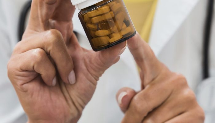 doctor-pointing-bottle-pills