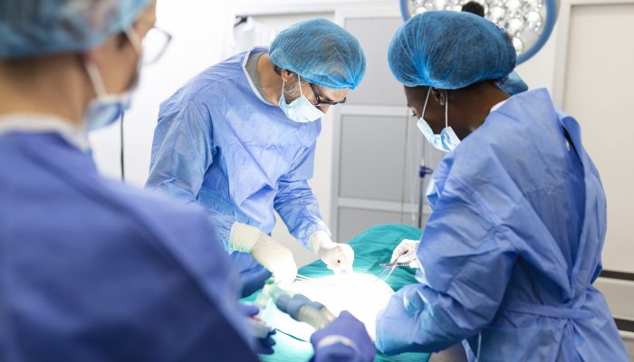 Surgeon team in uniform performs an operation on a patient at a cardiac surgery clinic. Modern medicine, a professional team of surgeons, health.