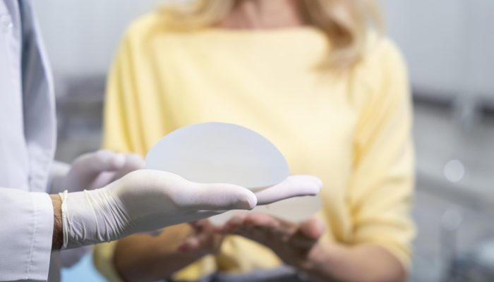 feche-as-maos-segurando-o-implante-mamario