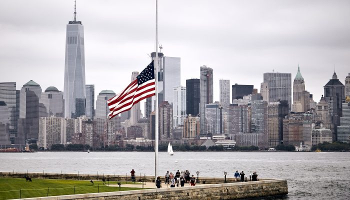 An amazing shot of the US flag in a park on the Manhattan skyline background