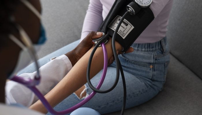 high-angle-doctor-checking-patient-s-blood-pressure