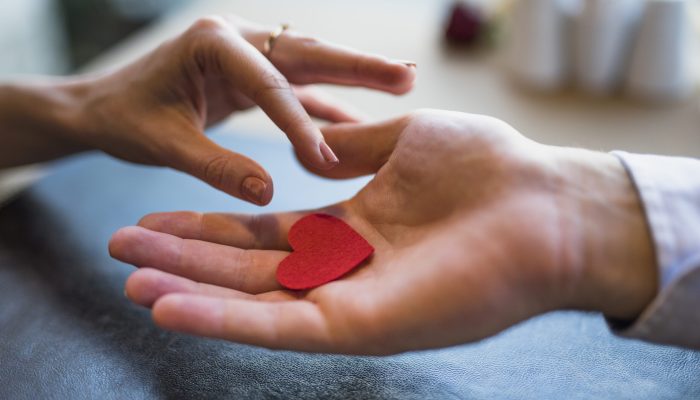 homem-dar-ornamento-vermelho-coracao-para-mulher