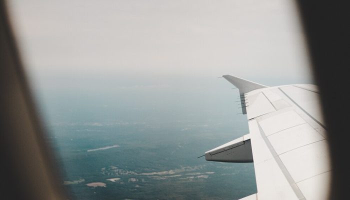 janela-do-aviao-com-vista-para-os-campos-verdes-acima-e-a-direita_181624-1554