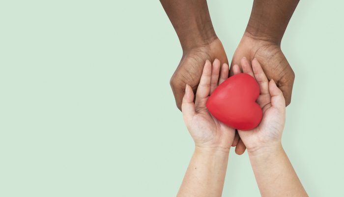 Hands cupping heart in love and relationship concept