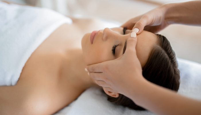Calm girl having spa facial massage in luxurious beauty salon