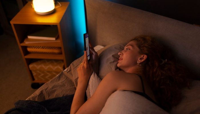 mulher-de-alto-angulo-deitada-na-cama_23-2150671598