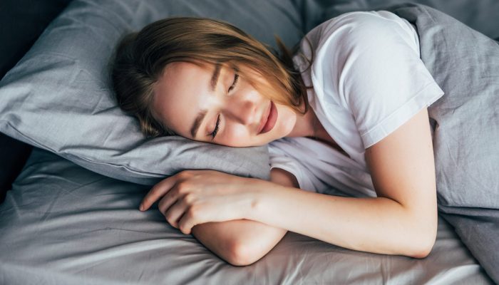 Woman sleeping. Beautiful young smiling woman sleeping in bed
