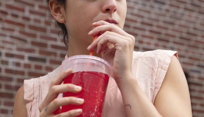 mulher-jovem-tolerando-onda-de-calor-com-uma-bebida-gelada