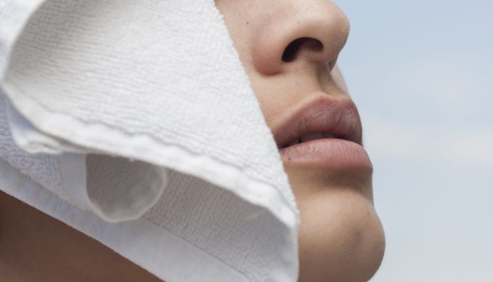 mulher-que-levanta-com-uma-toalha-branca-em-sua-cabeca