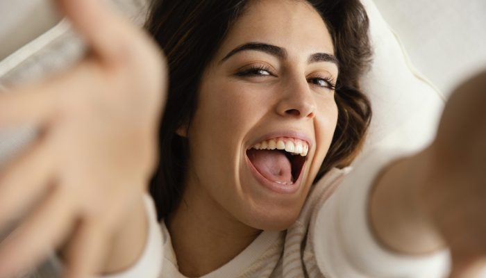 mulher-sorridente-em-casa-na-cama