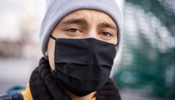 Portrait of food courier with black medical, watching into camera. Food delivery service