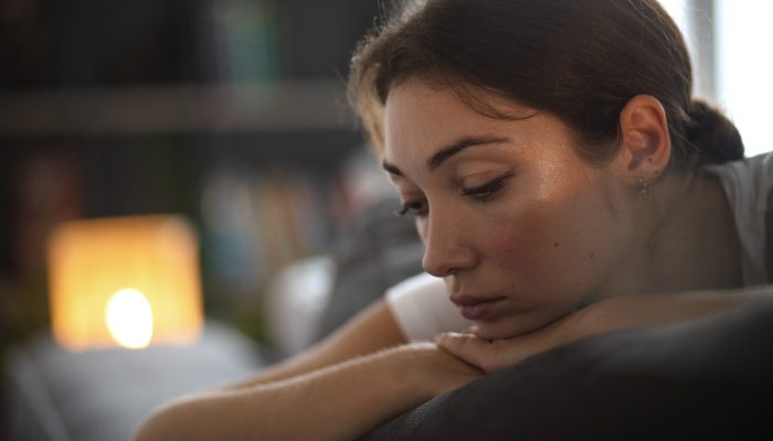retrato-de-jovem-com-baixa-autoestima-sentada-no-sofa-em-casa
