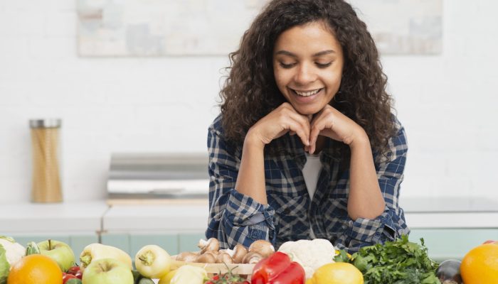 retrato-de-mulher-sorridente-olhando-legumes