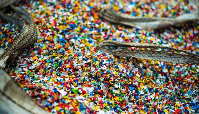 Sack of sorted multicoloured shredded plastic garbage at waste recycling factory