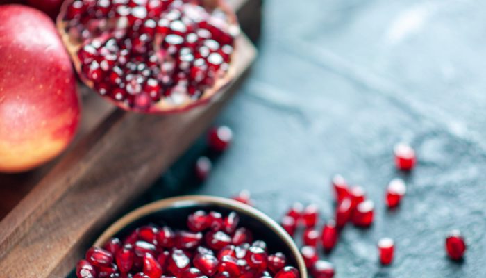 top-view-pomegranate-seeds-bowl-pomegranates-wood-serving-board-table